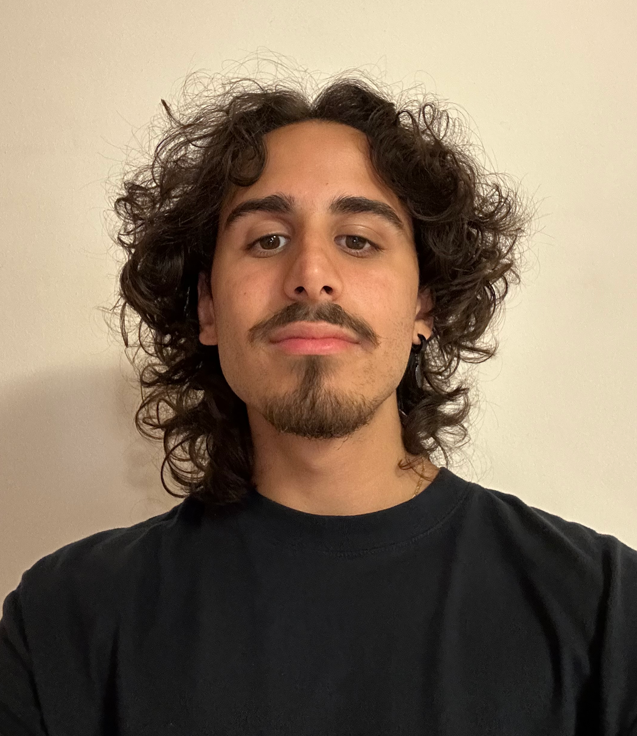 Foto di Belal Menzak con un leggero sorriso con uno sfondo neutro